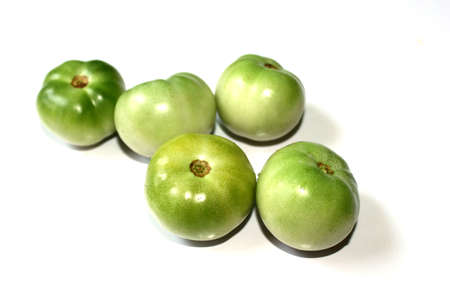 unripe green tomatoes fresh vegetable isolated on white backgroundの写真素材