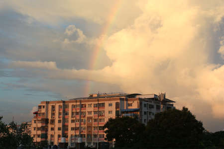 Rainbow Over Downtown against the background of dark storm clouds.worsening weather, Summer sky, rainbow over a building, selective focus with blur.の写真素材