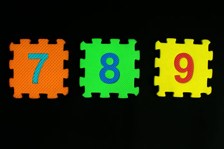 Colorful number puzzle isolated on black background. Number learning block for children education.の写真素材