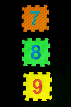 Colorful number puzzle isolated on black background. Number learning block for children education.