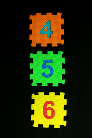 Colorful number puzzle isolated on black background. Number learning block for children education.の写真素材