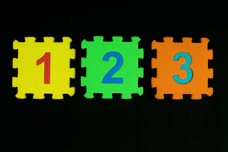 Colorful number puzzle isolated on black background. Number learning block for children education.の写真素材
