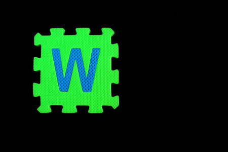 Colorful alphabet puzzle isolated on black background. alphabet learning block for children education.の写真素材