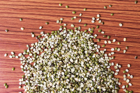 Split Mung Bean Lentils Also Know as Mungbean, Mung Gram, Vigna Radiata, Green Gram, Golden Gram Legumes, Moong Bean, Moong Dal, Green Bean or Mung Daal in bowl on wooden backgroundの写真素材