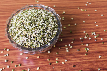 Bowl of green quinoa seeds on wooden table. Top view.