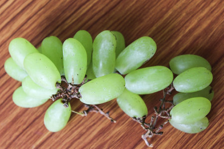 green grape on brown wooden backgroundの写真素材