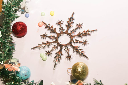 Season's greetings scene. Christmas decorations,gift boxes with red ribbons, Ñhristmas balls, rustic star, holly berries, frosty spruce branches, confetti on white backdrop, selective focus with blurの写真素材