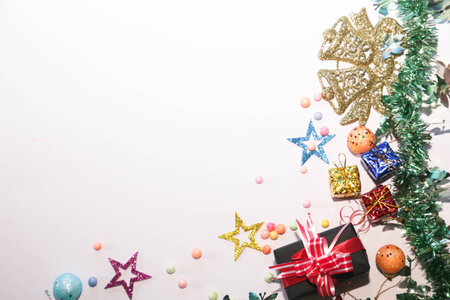 Season's greetings scene. Christmas decorations,gift boxes with red ribbons, Ñhristmas balls, rustic star, holly berries, frosty spruce branches, confetti on white backdrop, selective focus with blurの写真素材