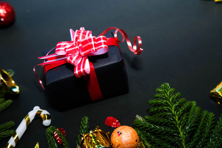 Deluxe holiday wishes concept. Top view of luxurious gift packages,Christmas and New Year background on black. Decorative border of fir branches, gift boxes, Christmas balls and candy cane on black backdrop text or ad spaceの写真素材