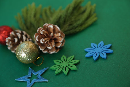 Season's greetings scene.Share your warm wishes with this image idea.view of magnificent gift box with ribbon, sparkling ornaments, frosty fir, ball, cone on green backdrop, ready for personalized adの写真素材