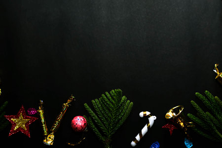 Season's greetings scene.Share your warm wishes with this image idea.view of magnificent gift box with ribbon, sparkling ornaments, frosty fir, ball, cone on black backdrop, with space for your text.の写真素材