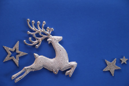 Beautiful christmas silver deer close up isolated on a blue background.Adorable reindeer with presents for christmas decoration.の写真素材