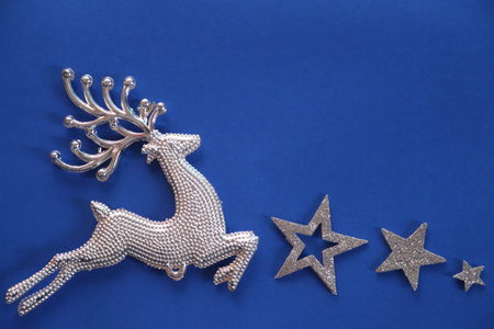 Beautiful christmas silver deer close up isolated on a blue background.Adorable reindeer with presents for christmas decoration.の写真素材