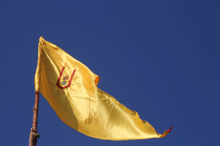 Yellow flag against the background of clear blue skyの写真素材