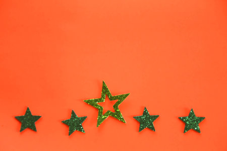 Origami stars on color background, sparkling stars on a orange background. Flat lay. Place for text.の写真素材