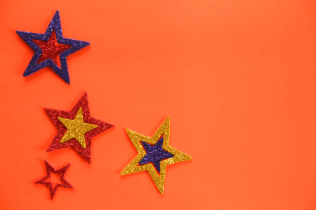 Origami stars on color background, sparkling stars on a orange background. Flat lay. Place for text.の写真素材
