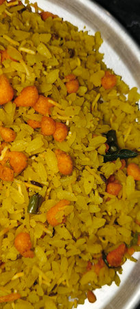 indian breakfast dish poha.Indian breakfast Poha topped with peanuts, pomegranate seeds, chopped green chilly, onion, lime, coriander leavesの写真素材