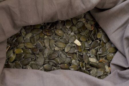 Organic raw peeled pumpkin seeds in a grey sack