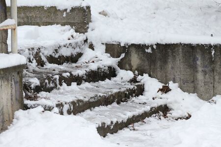 Winter. Stairs. People walk on a very snowy stairs. Uncleaned icy stairs in front the buildings, slippery stairsの写真素材