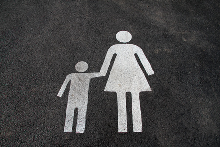 Parking space for mothers and children. Sign on asphalt âMother and childâ. Sign on the street âMom and kidâ. Pedestrian sign on asphalt. Parking space marking for mothers with children.の写真素材
