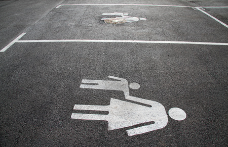 Parking space for mothers and children. Sign on asphalt âMother and childâ. Sign on the street âMom and kidâ. Pedestrian sign on asphalt. Parking space marking for mothers with children.の写真素材
