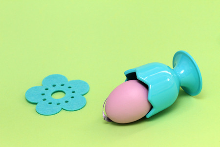 Easter eggs on green background with flowers. Purple decorative Easter eggs with decorative flowers. Purple egg and egg cup. Blue egg serverの写真素材