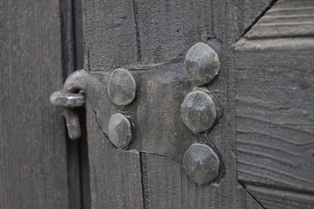 Real wooden texture with a hand-wrought iron element. Wood with iron background. A wooden door with...