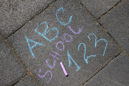 School, ABC letters and 123 sigh written with colored chalks on a pavement. Drawing Back to school...