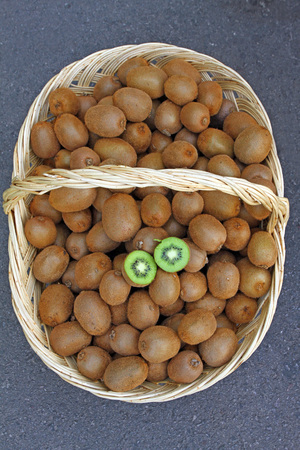 Kiwi. Fresh organic kiwis in knitted basket. Slice of colorful green kiwi fruit with seeds.の写真素材