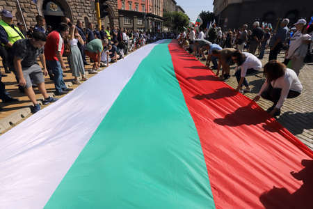 September 10, Sofia, Bulgaria: 64th day of protests against the mafia, the government and Attorney General Ivan Geshev. People unroll the Bulgarian flag in front of the institutions buildings.のeditorial素材