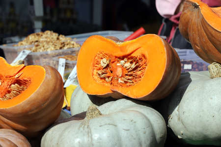Sliced and whole pumpkins , with seeds, at the market for Halloween and Thanksgiving