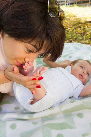 Mother love and kiss her little babyâs feetの写真素材