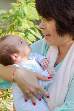 Mother love and kiss her little babyâs feetの写真素材