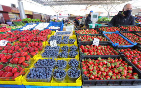 Man with face mask sell blueberries and strawberries at a farmerâs market in Sofia, Bulgaria on april 22, 2021のeditorial素材