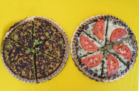 Two vegetarian pies with vegetables and vegan nutrients. Food on yellow background.の写真素材