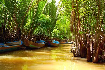 Small channel in Mekong Delta. Three boats in the harbourの写真素材