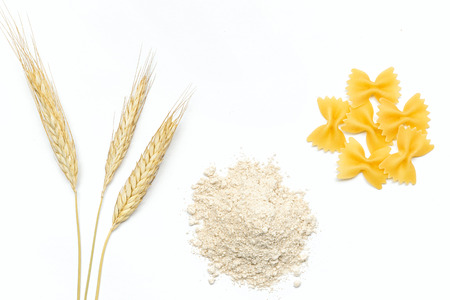 Pasta farfalle, wholemeal flour and ears wheat copy space,  white backgroundの写真素材