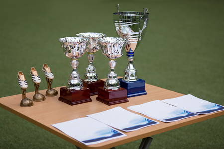 Cups and rewards on table, background of a football fieldの写真素材