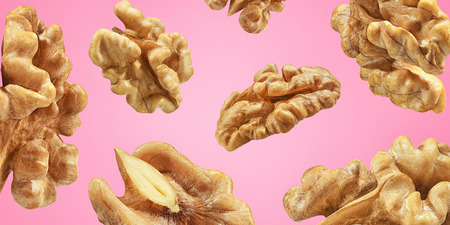 Creative layout made pattern walnuts isolated pink background. Macro concept. Mockup walnut  as package design element.の写真素材