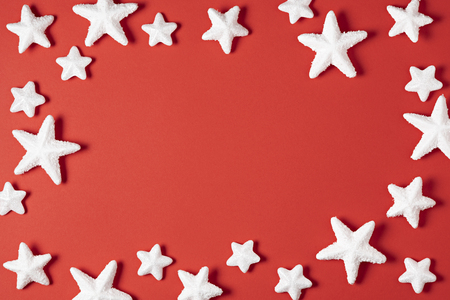 Beautiful christmas white stars on red paper background. Christmas decoration top view with copy spaceの写真素材
