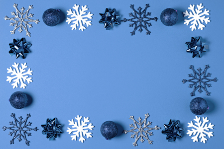 Christmas decorated with blue ball or baubles, white snowflakes on blue background top view. Merry Christmas greeting card. Winter xmas holiday theme.の写真素材