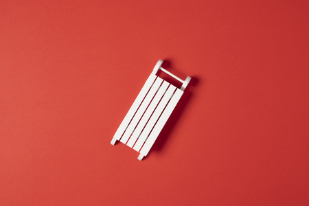 Christmas pattern white sledge on red background. Winter minimal concept. Flat lay.の写真素材