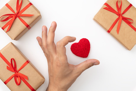 Mens hand shape heart near red heart and present box top view isolated white background. Valentines day concept decoration gift box of craft paper flat lay.の写真素材