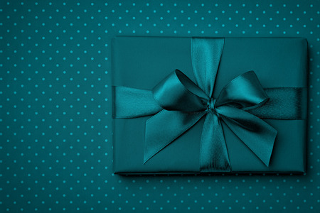 Dark turquoise gift box flat lay on dark turquoise background. Concept present box decoration...