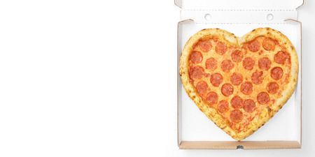 Pizza Heart Shaped top view in cardboard box for delivery Valentine Day with copy space isolated on white background. Pizza delivery. View from above. Valentines Day pizza concept.の写真素材