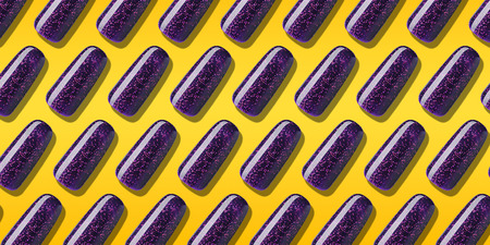 Pattern Nail polish purple color with glitter. Creative layout violet nail lacquer in tips on orange background. Top view.の写真素材