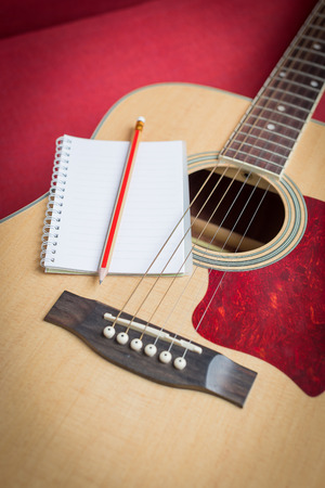 Notebook and pencil on guitar for writing musicの写真素材