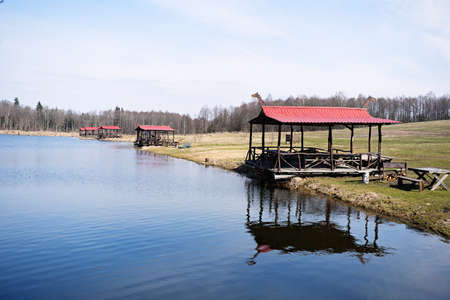 gazebos with a red roof on the shore of a spring lakeの写真素材