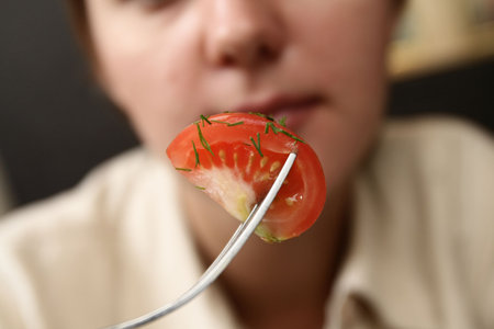 Titbit of tomato with dill on fork