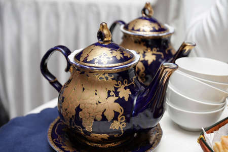 The two teapot with cups in the cafeの写真素材